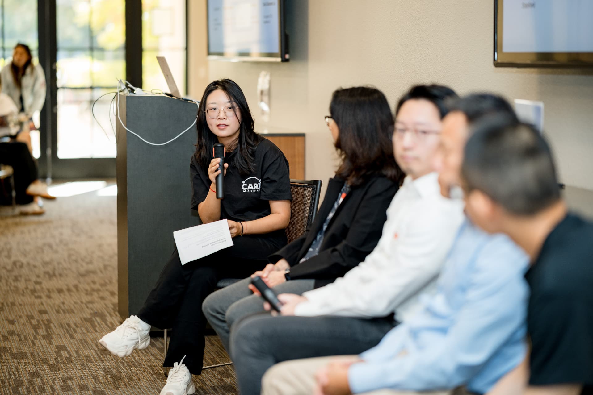 Crane Huang moderating a panel at the Care at a Distance event